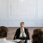 Woman in Black Blazer Sitting on Chair